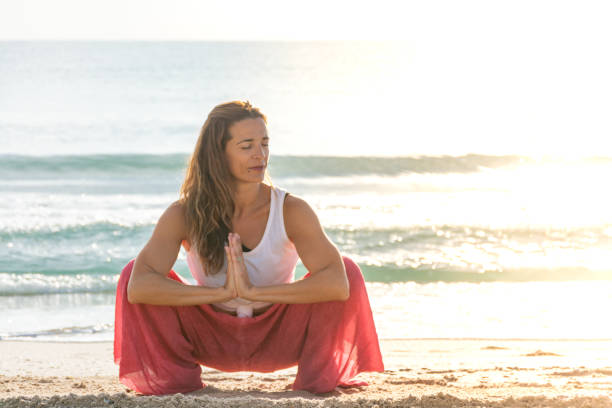 istock Woman doing the garland pose 1348113693