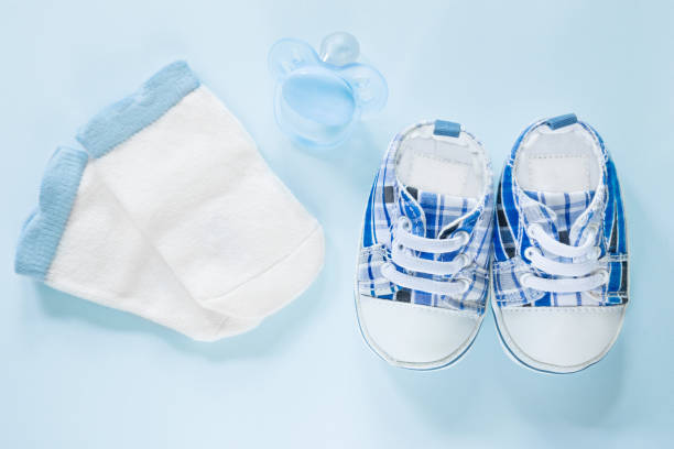 istock Top view on children's blue sneakers, socks and silicone pacifier 1348119445