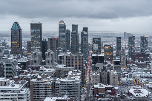 Montreal city skyline during a cloudy and snowy sunrise of winter seen from the Mount Royal.