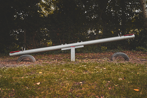 Isolated seesaw in a park in a dark mood.