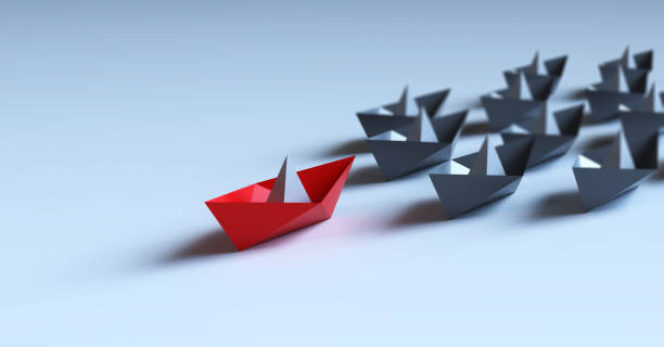 istock Leadership concept with red paper ship leading among white 1348129780