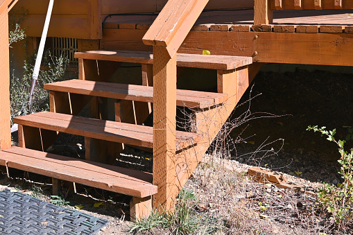 Wooden steps from porch or deck of cabin.