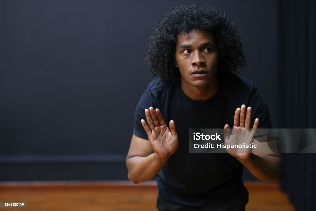 African American drama student improvising in an acting class Portrait of an African American drama student improvising in an acting class and looking scared Theatrical Performance Stock Photo
