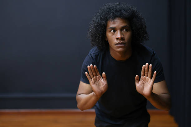 African American drama student improvising in an acting class Portrait of an African American drama student improvising in an acting class and looking scared theater class stock pictures, royalty-free photos & images