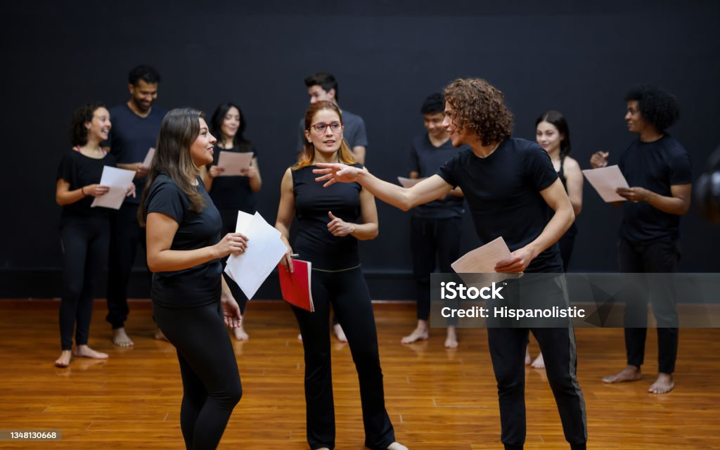 Acting students doing an improv exercise in a drama class Latin American acting students doing an improv exercise in a drama class with the guidance of their coach Theatrical Performance Stock Photo