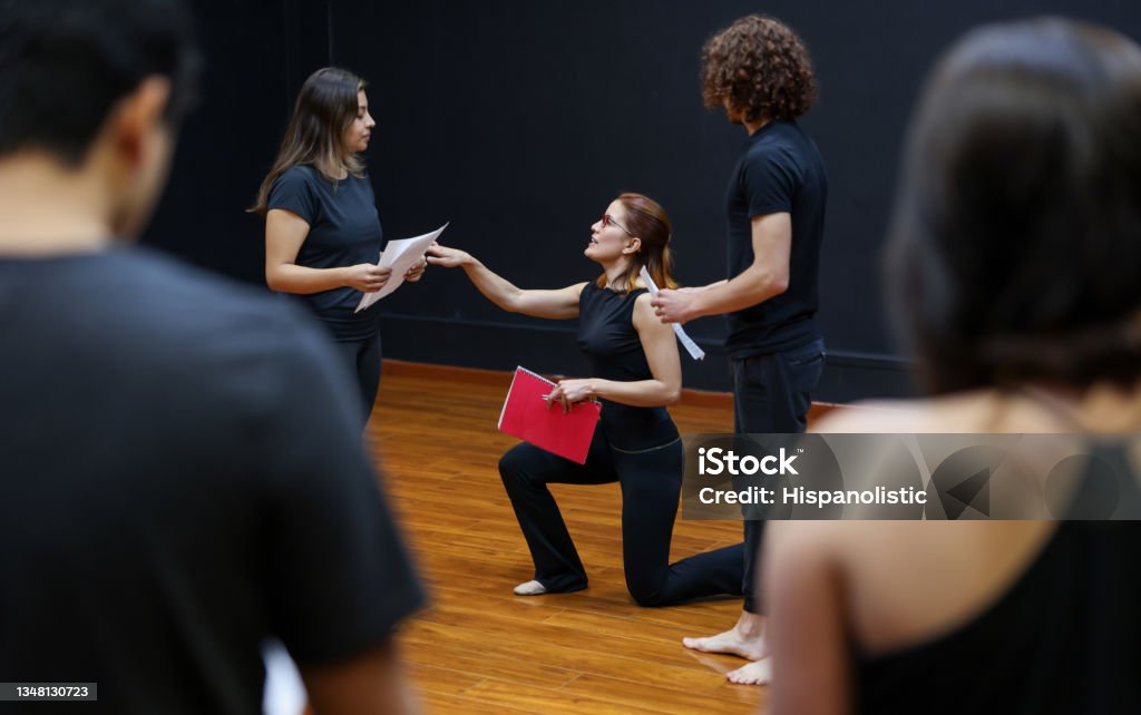Acting coach directing an improv exercise with her students in a drama class Latin American acting coach directing an improv exercise with her students in a drama class Theatrical Performance Stock Photo