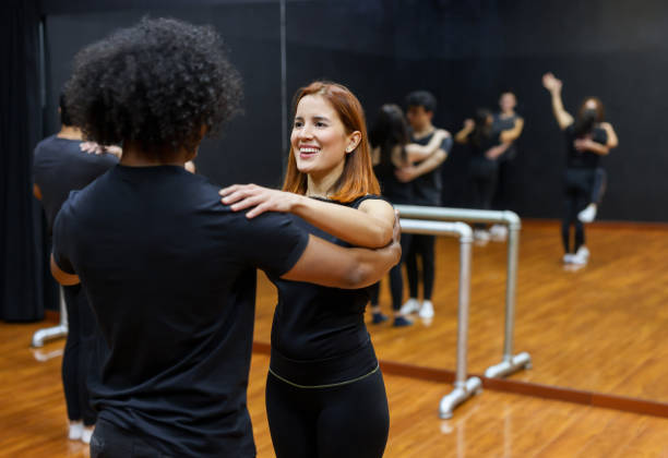 Happy couple taking dancing lessons Happy Latin American couple taking dancing lessons at a dance studio and smiling dance studio instructor stock pictures, royalty-free photos & images
