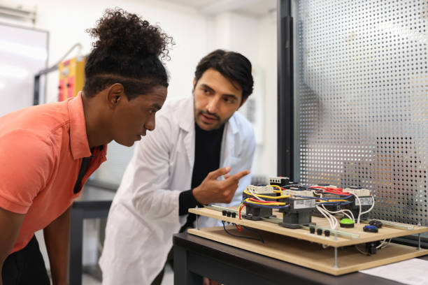 Teacher teaching an African American student in a robotics class