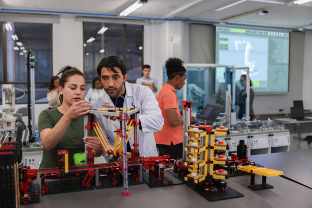 istock Teacher helping a female student in a robotics class at the university 1348130758