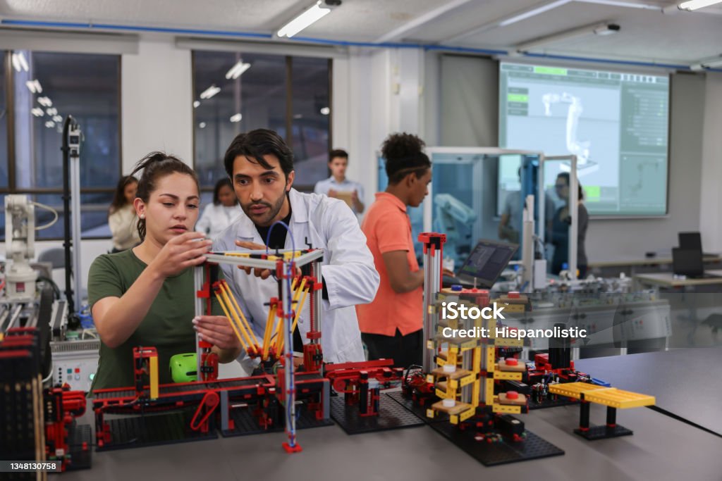 Teacher helping a female student in a robotics class at the university Teacher helping a female student in a robotics class at the university while building a project - STEM education concepts Student Stock Photo