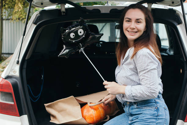 Young woman with Halloween balloon outdoors at the car stock photo
