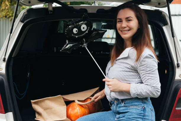 Young woman with Halloween balloon outdoors at the car stock photo