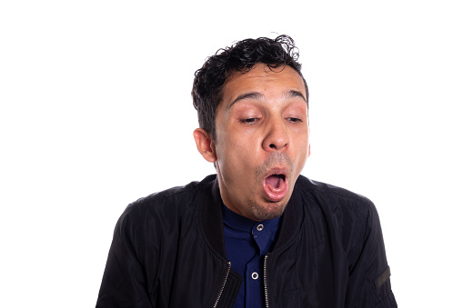 Disgusted man retching with vomit. White background. Young adult latino young man about to vomit from disgust. Face expressions.