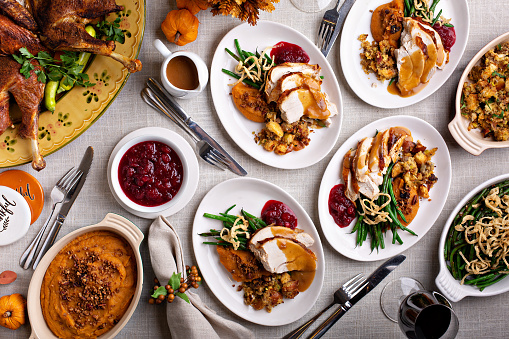 Festive Thankgiving dinner table with plates of food