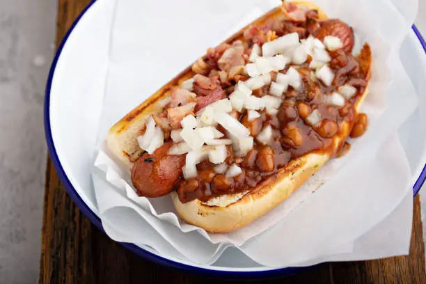 Chili hot dog with beans, bacon and onion