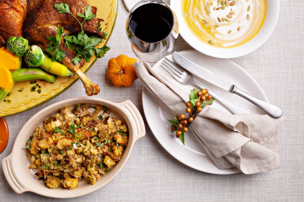 Thanksgiving dinner place setting with whole turkey, sides and pumpkin soup, overhead shot