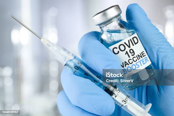 Hand In Blue Medical Gloves Holding A Syringe And Vaccine Vial With Covid 19 Vaccine Booster Text For Coronavirus Booster Shot Stock Photo - Download Image Now
