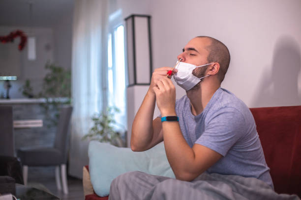istock Young man coronavirus covid-19 self testing with Antigen kit at home 1348139197