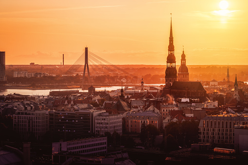 Aerial view of Riga in a golden light sunset with St Peters Church, Riga Cathedral and Vansu Bridge - Riga, Latvia