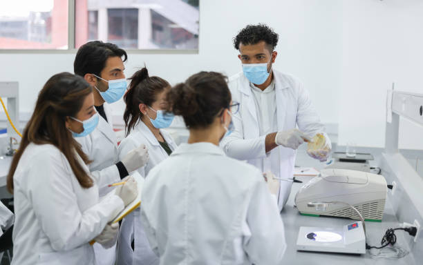 alunos em uma aula de bacteriologia aprendendo a usar um microscópio - estudante de medicina - fotografias e filmes do acervo