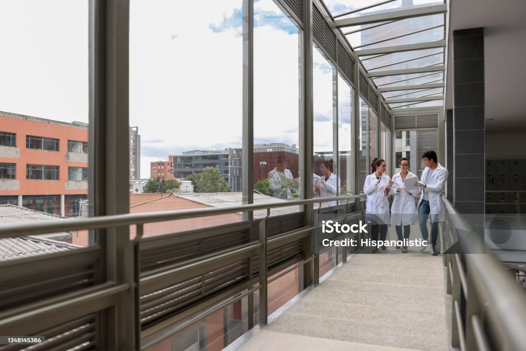 Group of medical students walking at the university Group of Latin American medical students walking at the university wearing lab coats and talking - education concepts Healthcare And Medicine Stock Photo