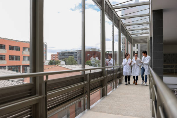 Group of medical students walking at the university Group of Latin American medical students walking at the university wearing lab coats and talking - education concepts civilian stock pictures, royalty-free photos & images