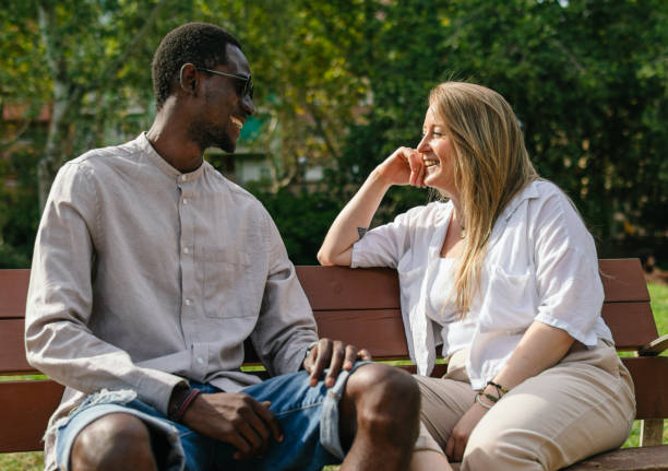 istock Handsome black man and blonde woman having a conversation on bench 1348146251