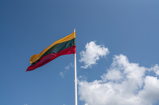 Bandera lituana en un cielo azul con nubes - Lituania photo