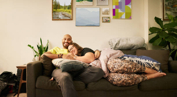 istock Smiling young couple relaxing together on their sofa in the evening 1348150512