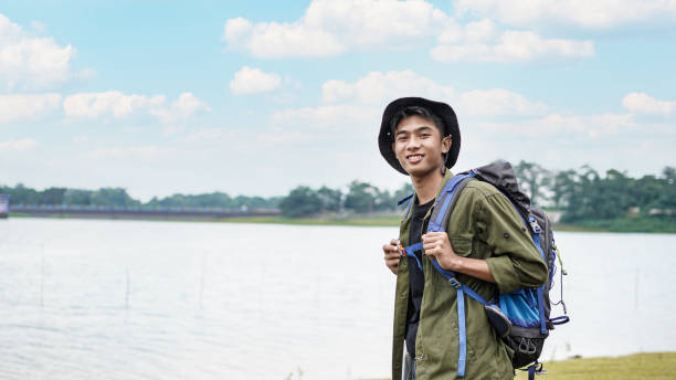 istock young Asian man traveler with backpack in reservoir 1348155687