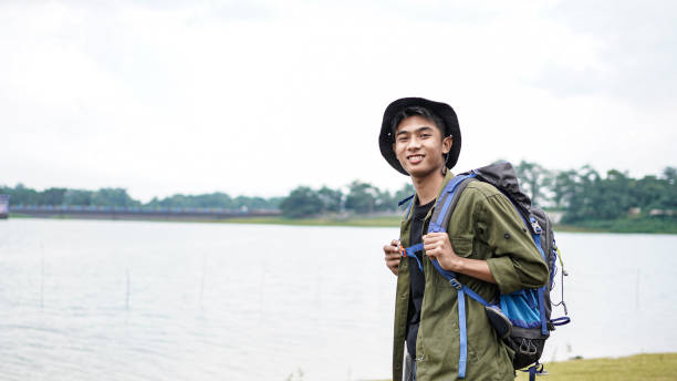 istock young Asian man traveler with backpack in reservoir 1348155789