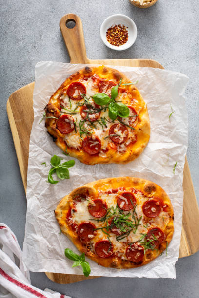 fladenbrot peperoni pizza mit basilikum - pizza pastry crust oven meat stock-fotos und bilder