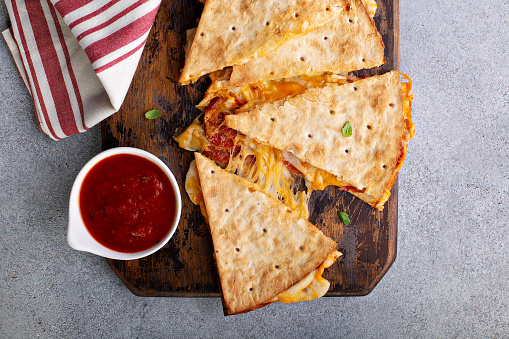 Pizza quesadilla with pepperoni and marinara sauce with cheese pull