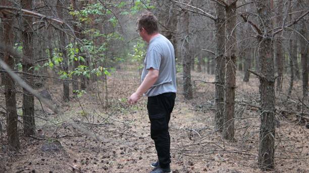 istock a lonely man with glasses walks through a dark forest 1348159007