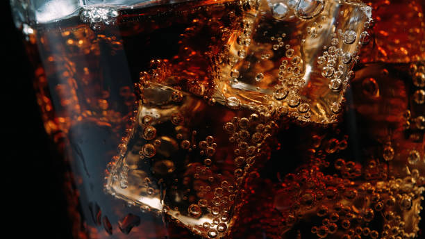nahaufnahme eines glases cola mit eiswürfeln und blasen - foods and drinks simplicity purity image technique stock-fotos und bilder