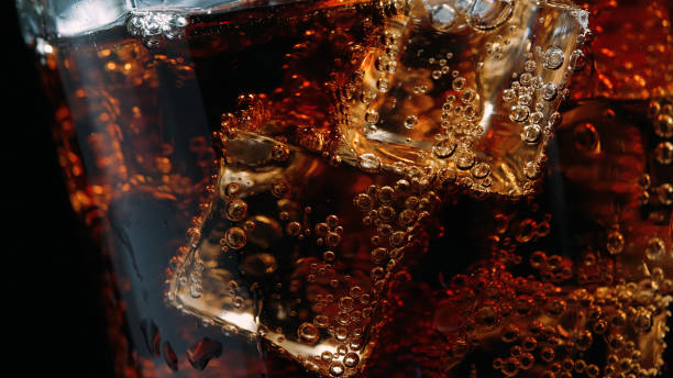 Close-up of a glass of cola with ice cubes and bubbles Close-up of a glass of cola with ice cubes and bubbles1 coca cola stock pictures, royalty-free photos & images