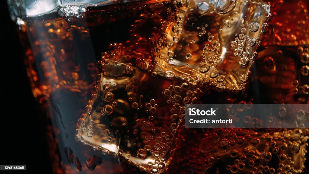 Zbliżenie szklanki coli z kostkami lodu i bąbelkami - Zbiór zdjęć royalty-free (Cola)