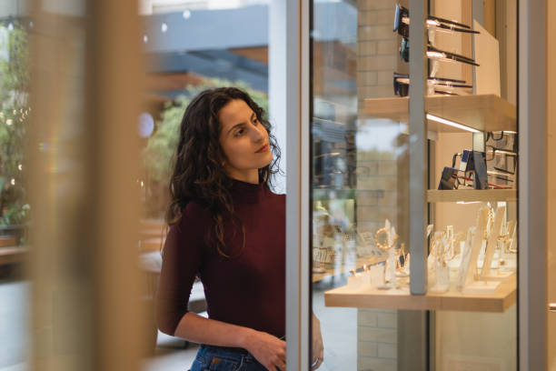 istock Woman looking at a shop window with glasses on display. 1348173313