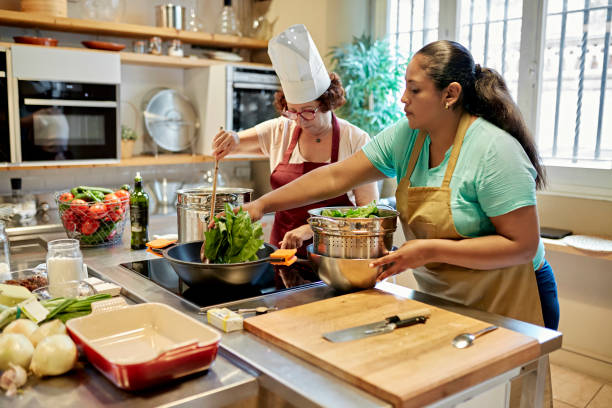 istock Chef and Student Cooking Together in Classroom Environment 1348173368