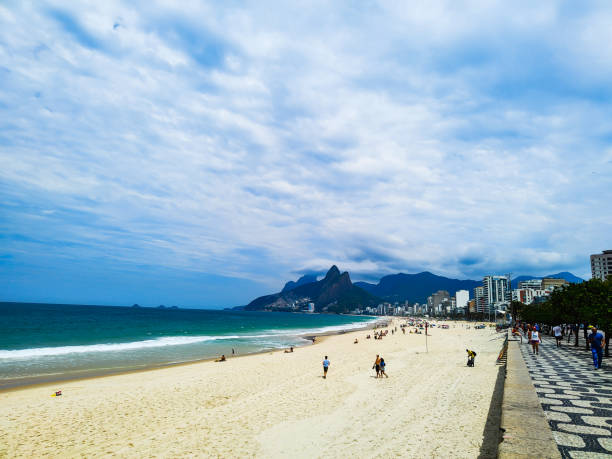 istock Beach line with walking people, sky and promenade 1348177266