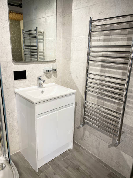 istock Image of luxury bathroom suite, white vanity unit, ceramic sink with chrome monoobloc single lever tap, separate, curved shower cubicle, sliding, panelled glass door, chrome, ladder towel rail radiator 1348184586