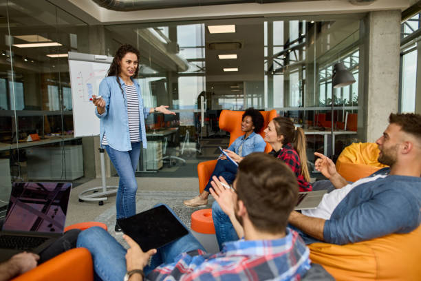 istock Female programmer giving a presentation about new ideas to her colleagues in the office 1348185652