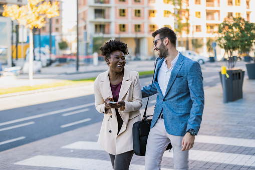 Commuters in the city, business people with a smartphone. Modern business man and woman wearing smart casual clothes in the city. Urban lifestyle