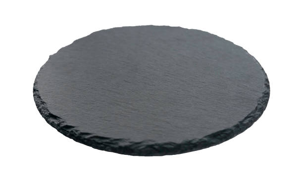 istock Selective focus of black slate round stone isolated on white background. 1348190411