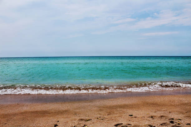 istock Blue sea wave on a pebble beach. 1348194915