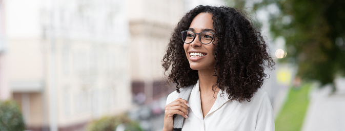 Woman looking up. Smiling student girl outdoor. African american businesswoman portrait. Student lifestyle, business people, positive emotions concept