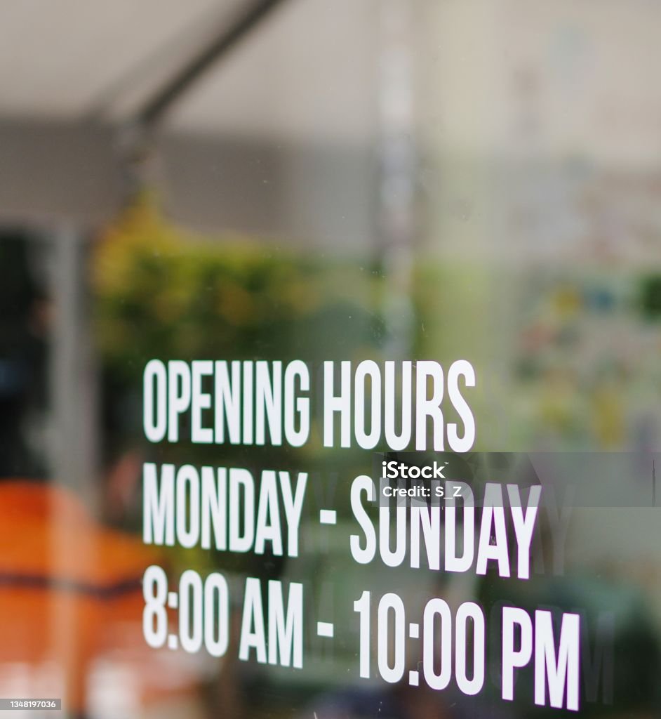 Opening hours shop window white decal sticker monday to sunday 8am to 10pm Store Window Stock Photo