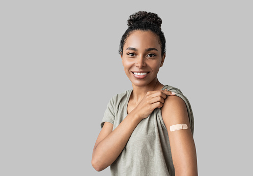 Retrato de una mujer joven con yeso en el brazo después de recibir una vacuna. photo