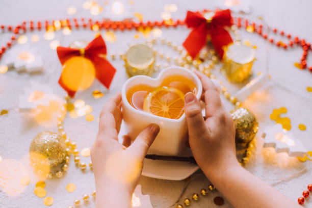 istock New Year's tea with hands on a white background . Glitter and white background. Holiday. Holiday decorations. The layout is a festive tea party. 1348201319