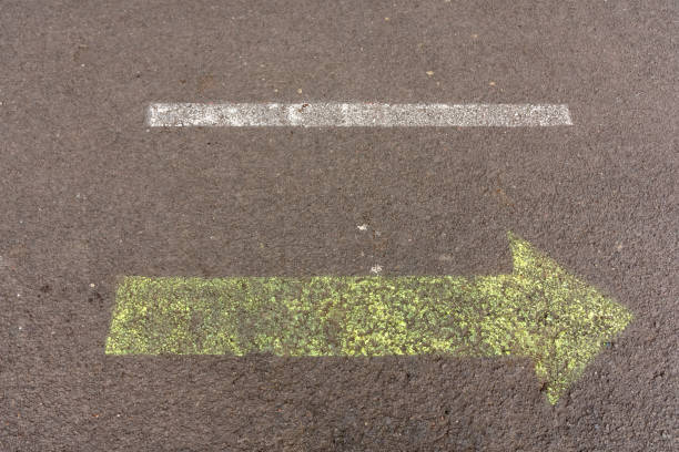 istock Yellow painted arrow in a lane on an asphalt road 1348204988